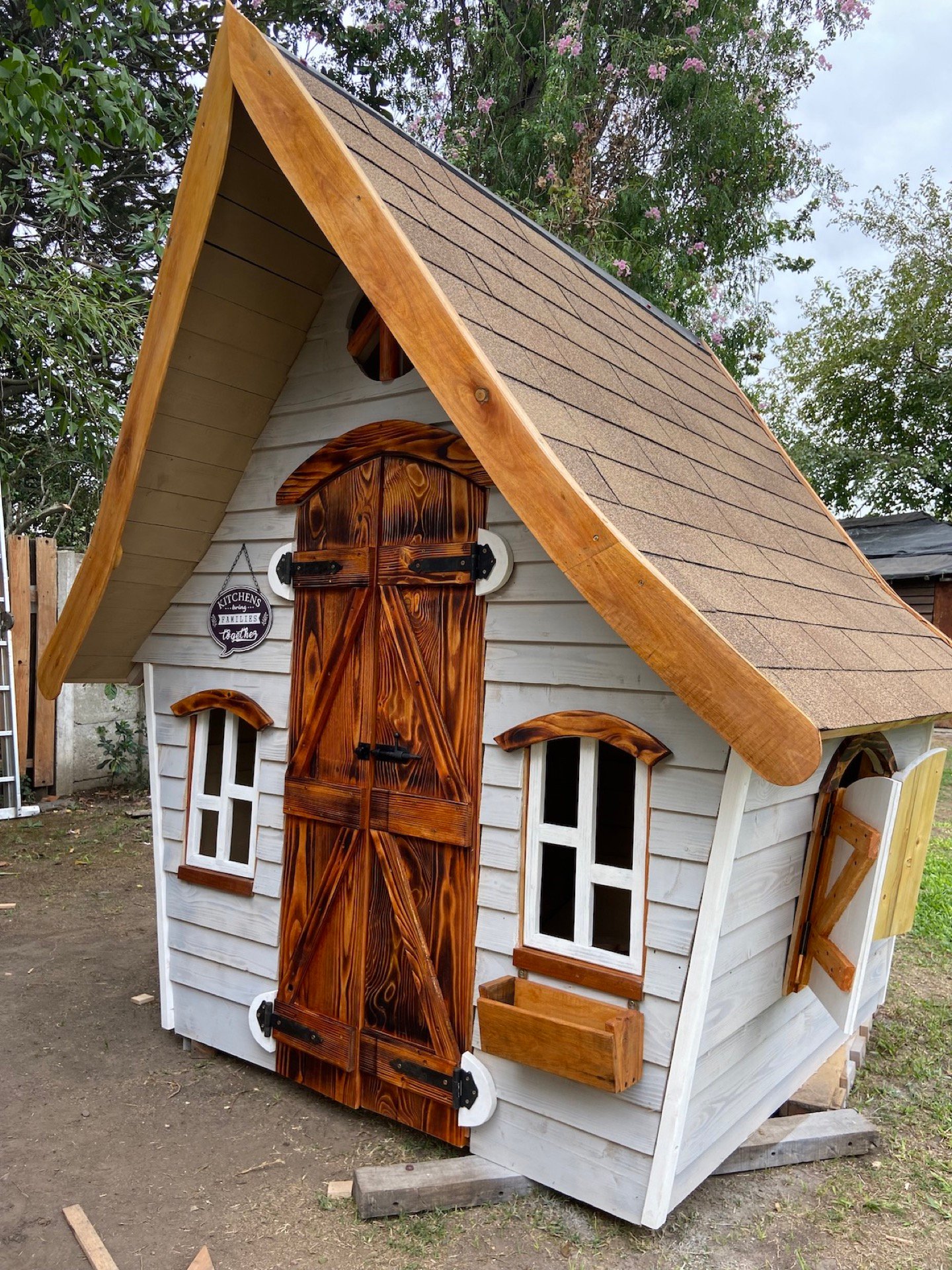 Casita blanca con techo de tejuela de madera, vista frontal