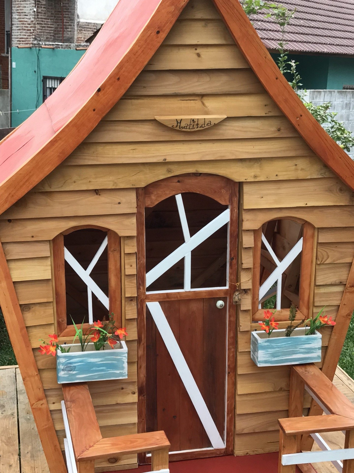 Detalle de puertas y ventanas con cruces de madera y macetas con flores